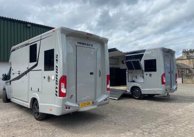 Two grey Aeos Horseboxes in yard